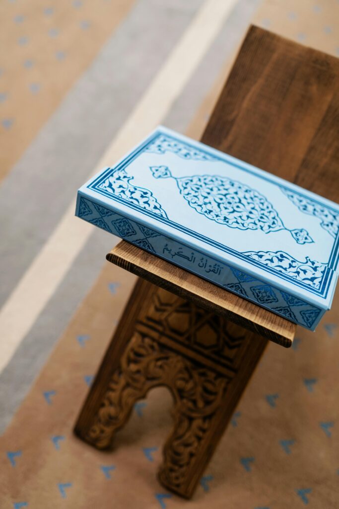 High-angle view of a Quran on an ornate wooden stand, symbolizing faith and spirituality.